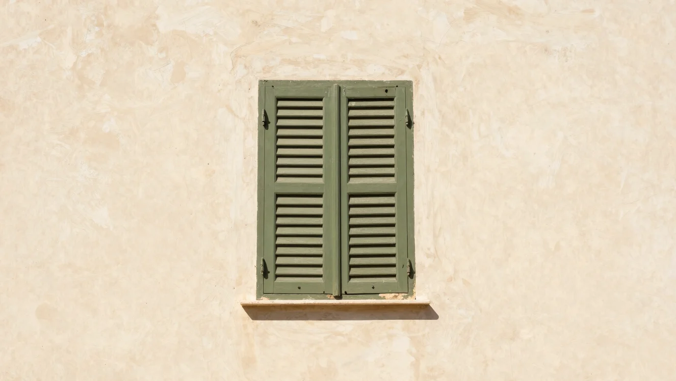 Close architectural detail of pale lime render and a wooden shutt